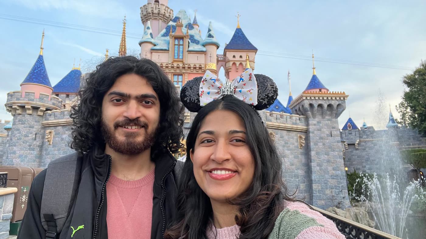 Abirami and Prateek outside the castle at Disneyland