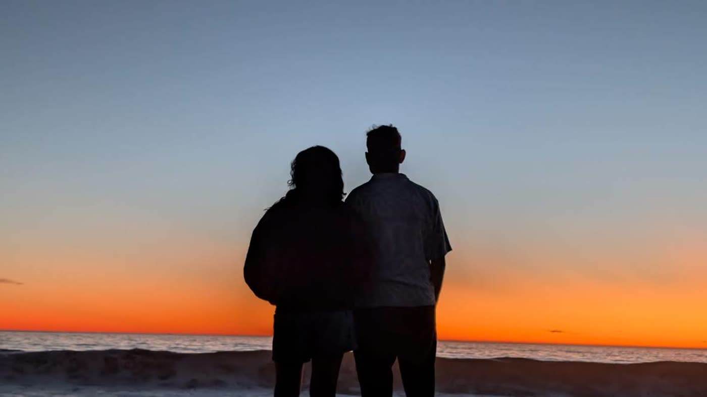 Abirami and Prateek watching the sun set over the sea